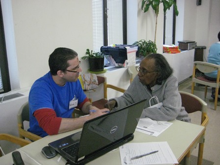 William finishes up Mildred's tax return in the community room of Rose Hill Apartments.